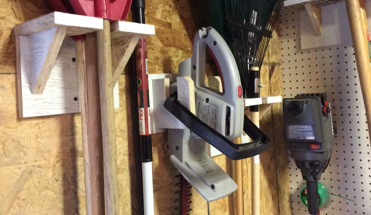 hedge trimmer hung on shelves in shed